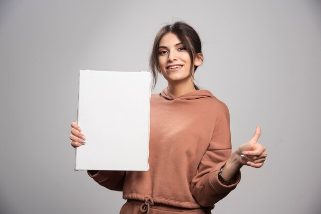 Jonge schilder poseren met canvas en duimen opgevend