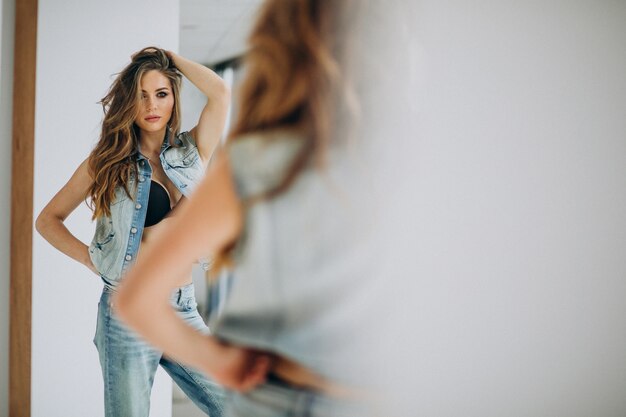 Jonge sexy vrouw st huis in denim outfit