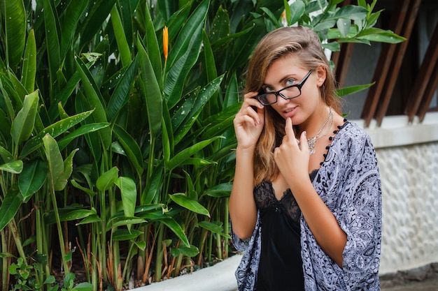 Jonge slanke vrouw in tropische villa Bali, bril en lingerie