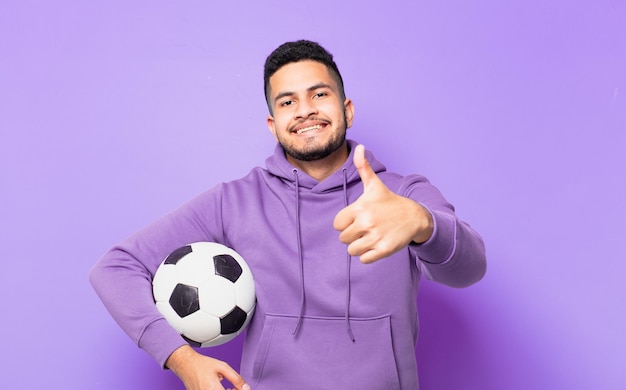 Jonge spaanse atleet man gelukkige uitdrukking en met een voetbal