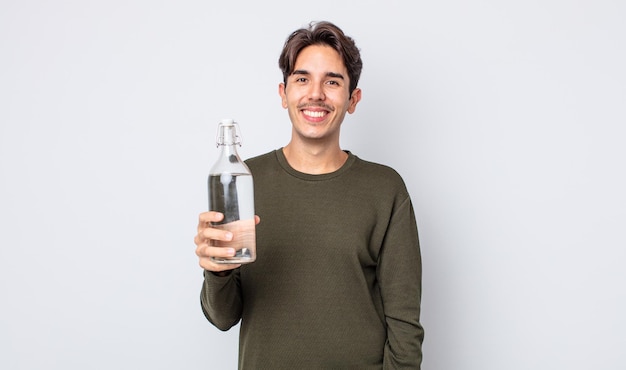 Jonge spaanse man die er blij en aangenaam verrast uitziet. waterfles concept Premium Foto
