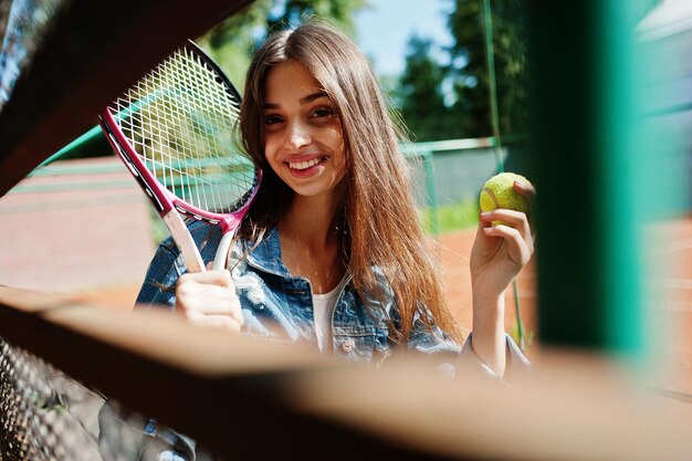 Jonge sportieve meisjesspeler met tennisracket op tennisbaan