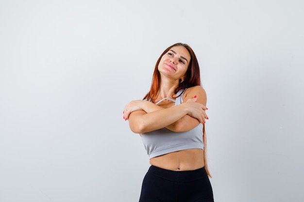 Jonge sportieve vrouw met lang haar in een grijze top