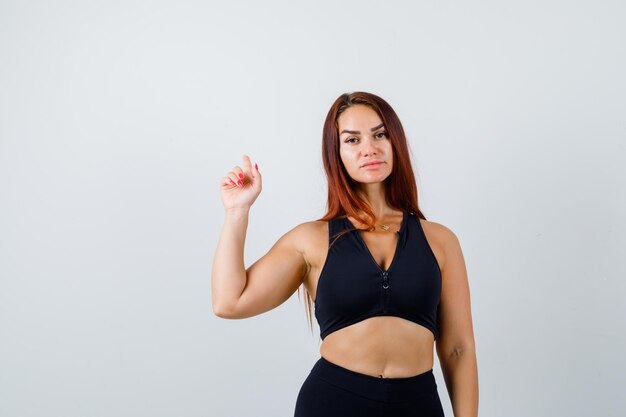 Jonge sportieve vrouw met lang haar in een zwarte top