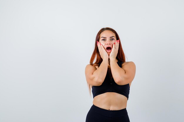 Jonge sportieve vrouw met lang haar in een zwarte top