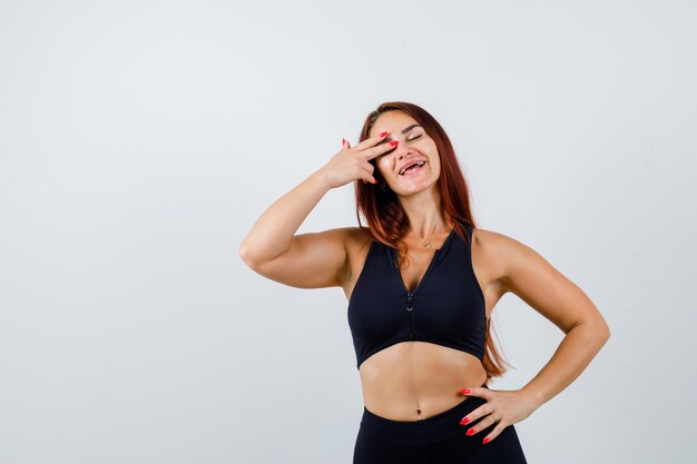 Jonge sportieve vrouw met lang haar in een zwarte top