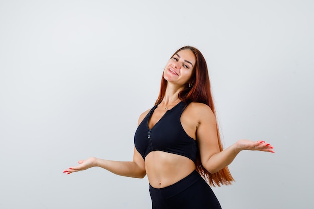 Jonge sportieve vrouw met lang haar in een zwarte top