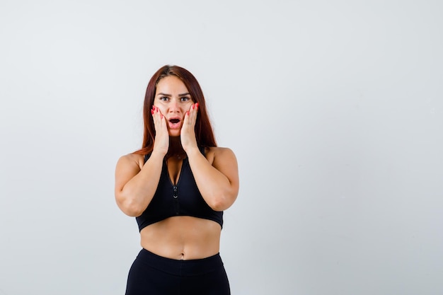 Jonge sportieve vrouw met lang haar in een zwarte top