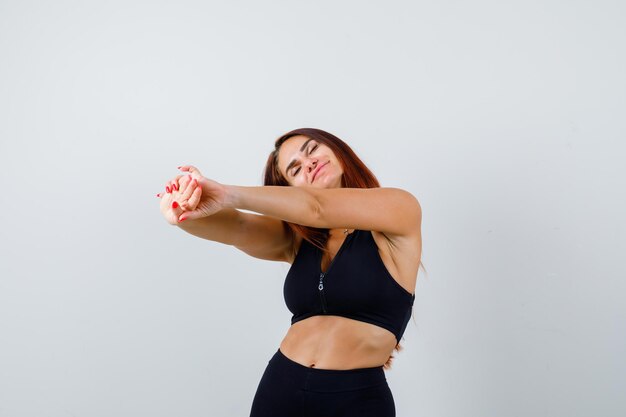 Jonge sportieve vrouw met lang haar in een zwarte top