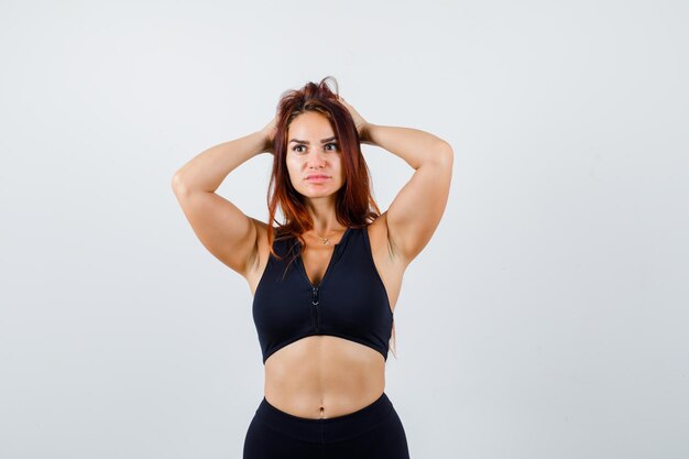 Jonge sportieve vrouw met lang haar in een zwarte top