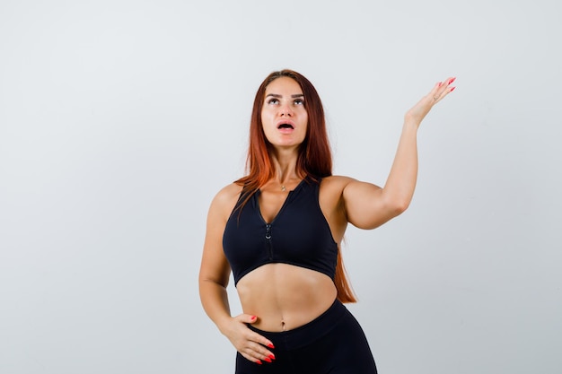 Jonge sportieve vrouw met lang haar in een zwarte top