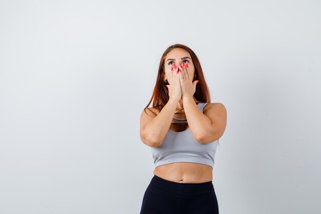 Jonge sportieve vrouw met lang haar verbaasd