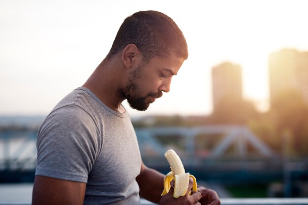 Jonge sportman die banaan eet na de training