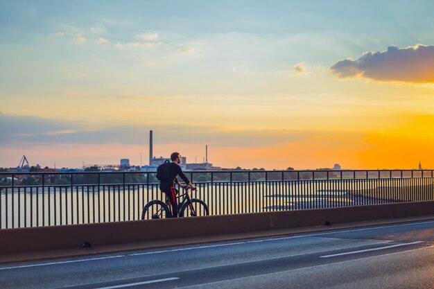 Jonge sportman op een fiets in een Europese stad. Sporten in stedelijke omgevingen.