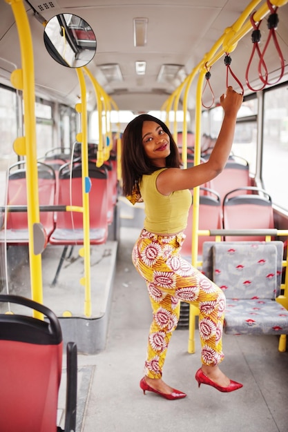 Gratis foto jonge stijlvolle afro-amerikaanse vrouw rijden op een bus