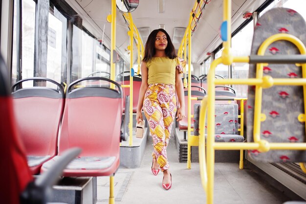 Jonge stijlvolle Afro-Amerikaanse vrouw rijden op een bus