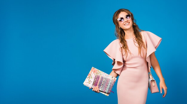 Jonge stijlvolle sexy vrouw in roze luxe jurk zomer modetrend, chique stijl, zonnebril, mode bloger