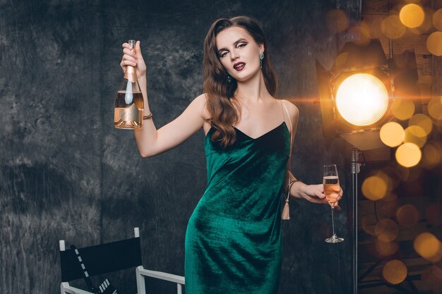 Jonge stijlvolle sexy vrouw op bioscoop backstage, vieren met een glas champagne