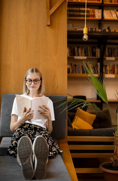 Jonge student die een boek leest in de bibliotheek