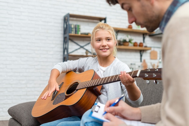 Gratis foto jonge student leren gitaar spelen