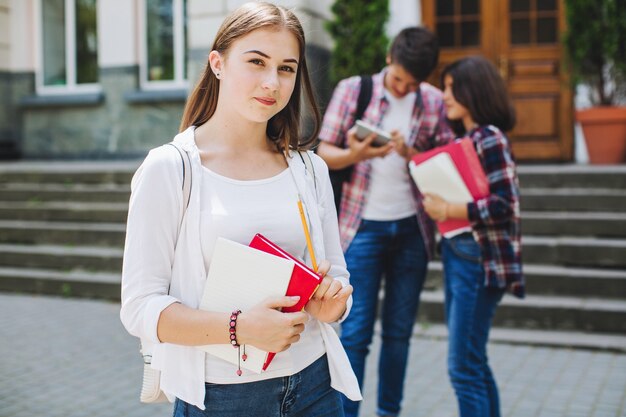 Jonge student poseren in de buurt van de universiteit