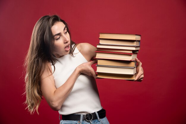 Jonge studente houdt een stapel boeken