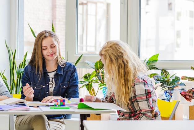 Jonge studenten aan tafel zitten