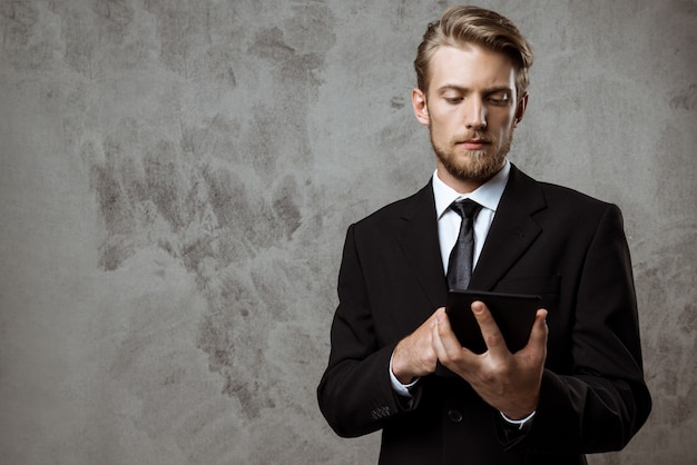 Jonge succesvolle zakenman die tablet bekijkt