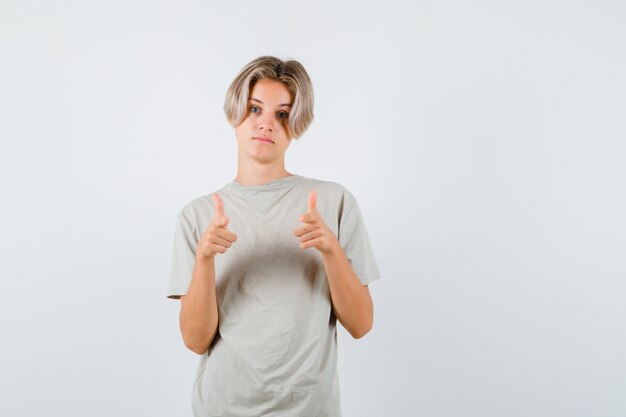 Jonge tienerjongen die naar voren wijst in een t-shirt en er teleurgesteld uitziet, vooraanzicht.