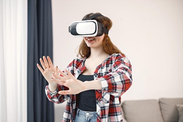 Jonge tienermeisje dat in de woonkamer staat met een virtual reality-bril