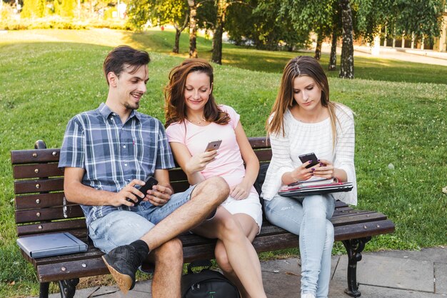 Jonge tieners met telefoons in het park