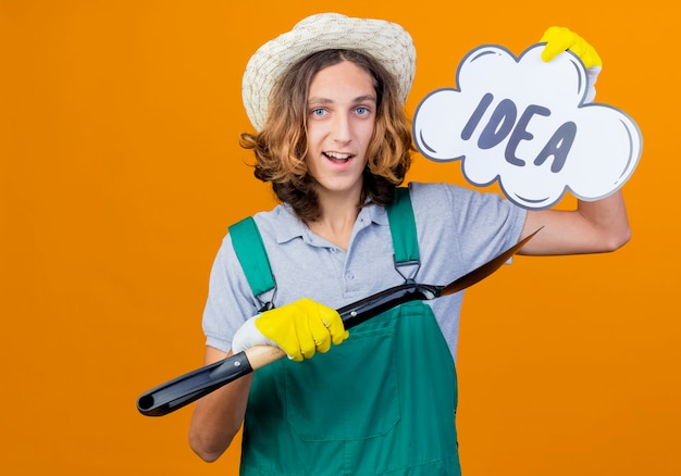 Jonge tuinman man in rubberen handschoenen dragen jumpsuit met schop en tekstballon