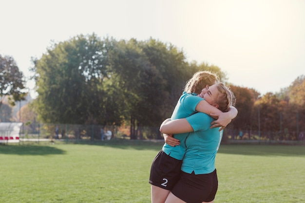 Jonge voetballers omhelzen elkaar