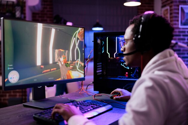 Jonge volwassen live streaming videogames-toernooi op pc online met meerdere spelers, actie-esport-game spelen op computer. Mannelijke streamer met headset die geniet van gaming-competitie.