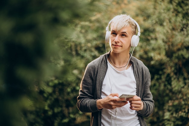 Jonge volwassen student in hoofdtelefoons in park