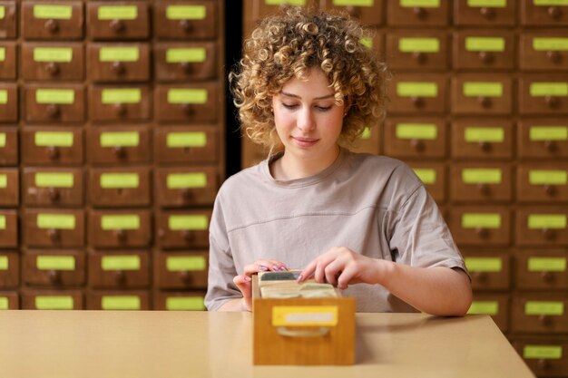 Jonge volwassene die in bibliotheekbureau werkt