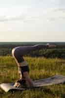 Gratis foto jonge volwassene genieten van yoga in de natuur