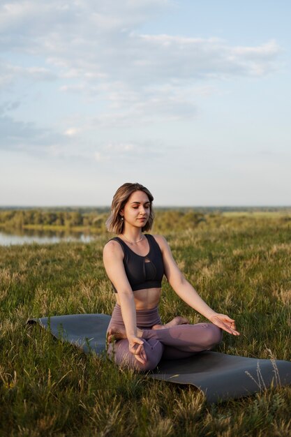 Jonge volwassene genieten van yoga in de natuur