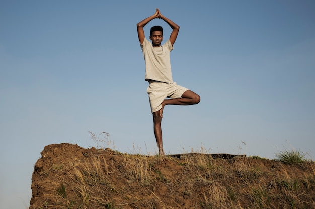 Jonge volwassene genieten van yoga in de natuur