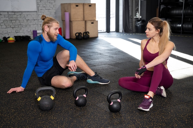 Gratis foto jonge volwassenen in sportgymnastiek met behulp van kettlebells