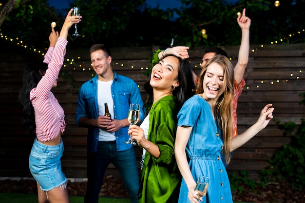 Jonge vrienden die samen in openlucht dansen