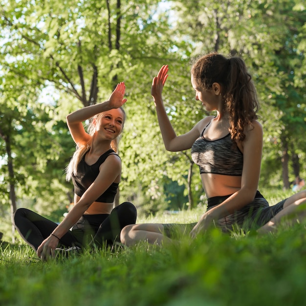 Jonge vrienden die yoga in het park doen