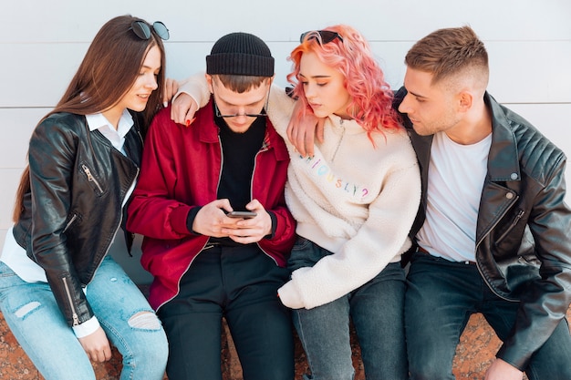 Jonge vrienden kijken naar mobiele telefoon