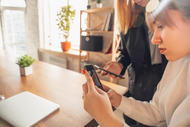 Jonge vriendenvrouwen die gadgets gebruiken