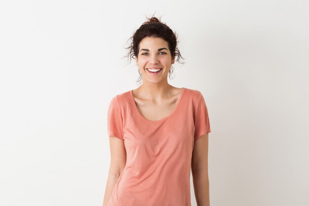 Jonge vrij natuurlijke vrouw, glimlachend, oprechte emotie, positief, gelukkig, geïsoleerd, roze t-shirt