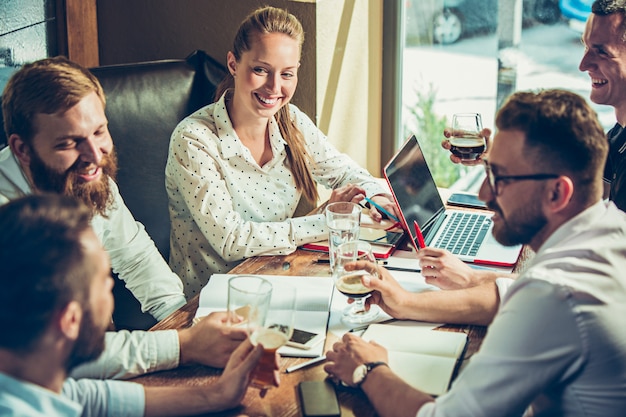 Jonge vrolijke mensen glimlachen en gebaar terwijl u ontspant in pub.