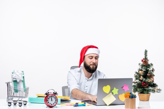 Jonge vrolijke zakenman die in bureau Nieuwjaar of Kerstmis vieren die alleen op witte achtergrond werken