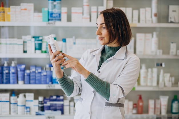 Gratis foto jonge vrouw apotheker bij apotheek