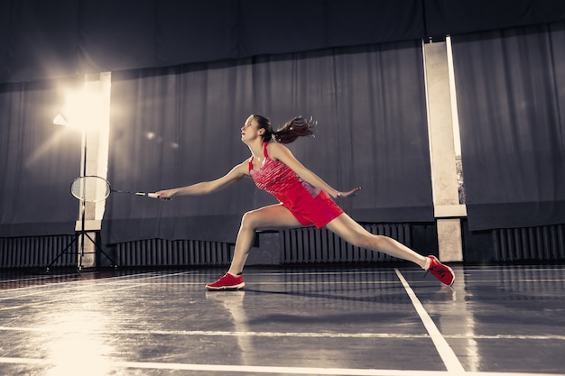 Jonge vrouw badminton spelen op sportschool