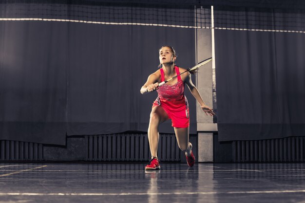 Jonge vrouw badminton spelen op sportschool